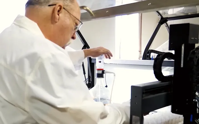 Lab technician loading soil extracts into an automated analyzer at the Alpena lab